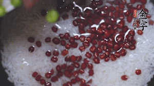 將炒好的食材和大米、紅豆一起放進(jìn)電飯鍋煮。