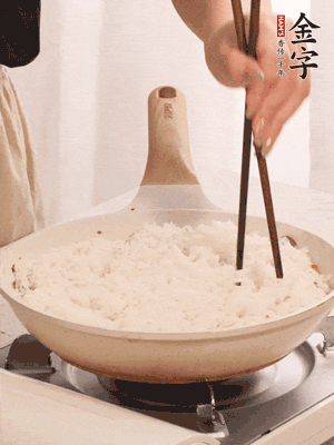 把瀝干水分的米飯均勻鋪在上面，筷子戳幾個洞，以便透氣，轉小火蓋上蓋子燜至水分收干，大概10分鐘。